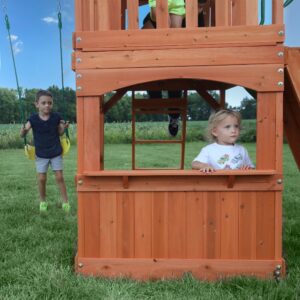 Young girl in swing set clubhouse